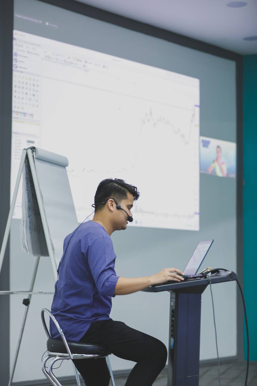 Hands holding smartphone with stock app, laptop displaying charts. Perfect for financial and technology themes.